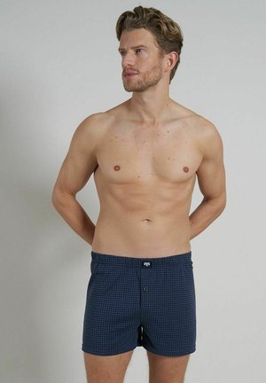 Navy blue checkered boxers made of lightweight fabric, featuring a button at the front and an elastic waistband for comfort.