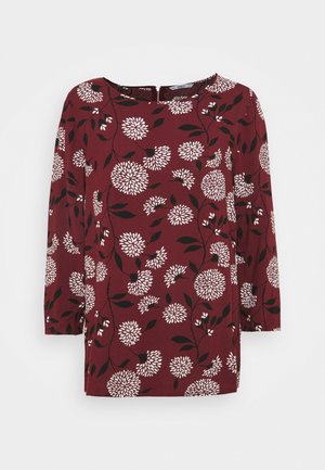 Bordeauxfarbige Bluse mit einem floralen Muster in Weiß und Schwarz, dreiviertelärmlig, runder Ausschnitt und lockerer Passform.