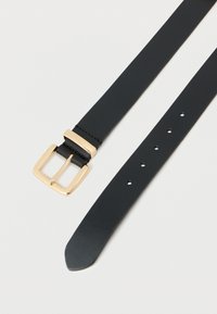 Μαύρη δερμάτινη ζώνη με χρυσή ορθογώνια αγκράφα και πέντε τρύπες ρύθμισης σε λευκό φόντο.