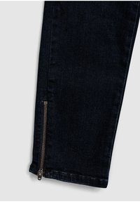 Tmavě modré džíny ze silné denimu s úzkým střihem a poklopcem na nohavici, se světlým lemem a jemným vyblednutím v textuře.