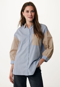 Camicia a righe blu chiaro e beige, con una vestibilità comoda, caratterizzata da tasche a toppa e maniche ampie con righe a contrasto.