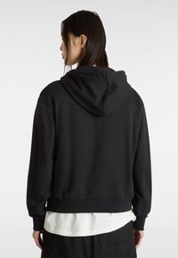 Felpa nera con cappuccio caratterizzata da una vestibilità comoda, polsini e vita a costine. Tessuto liscio con design minimalista, senza motivi o loghi visibili.