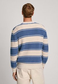 Sinise ja beeži triibulise kudumisega sviiter, millel on struktureeritud muster, ümmargune kaelus ning ribaga käised ja ääred.