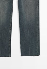 Jeans in denim a gamba larga con lavaggio scuro, caratterizzati da un orlo grezzo, una texture liscia e aree leggermente sbiadite per un look vintage.