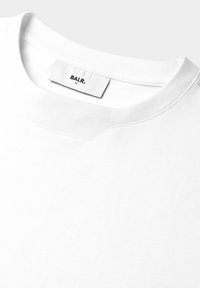 Bílý pánský tričko s kulatým výstřihem vyrobené z měkké bavlny, s jemně žebrovaným výstřihem a tištěnou etiketou "BALR." uvnitř.