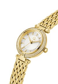 Gold-tone watch with a woven bracelet, round case, mother-of-pearl dial, and crystal accents around the bezel. Features gold hour markers.