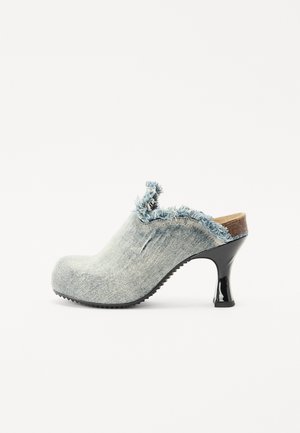 Denim-sandaali, jossa on rispaantunut reuna, korkea kiiltävä musta korko ja teksturoitu pohja. Ominaisuuksia ovat pyöreä kärki ja avonainen takaosa.