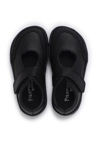 Zwarte leren schoenen met een ronde vorm, featuring uitsnijdingen aan de zijkanten en een klittenbandsluiting. Glad oppervlak met subtiele branding op de binnenzool.