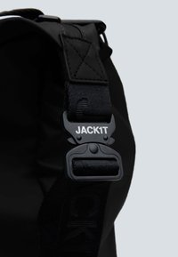 Cinghia nera per borsa a spalla con fibbia in plastica con il testo "JACK1T" e materiale in nylon testurizzato, con dettagli a punto croce alla base.