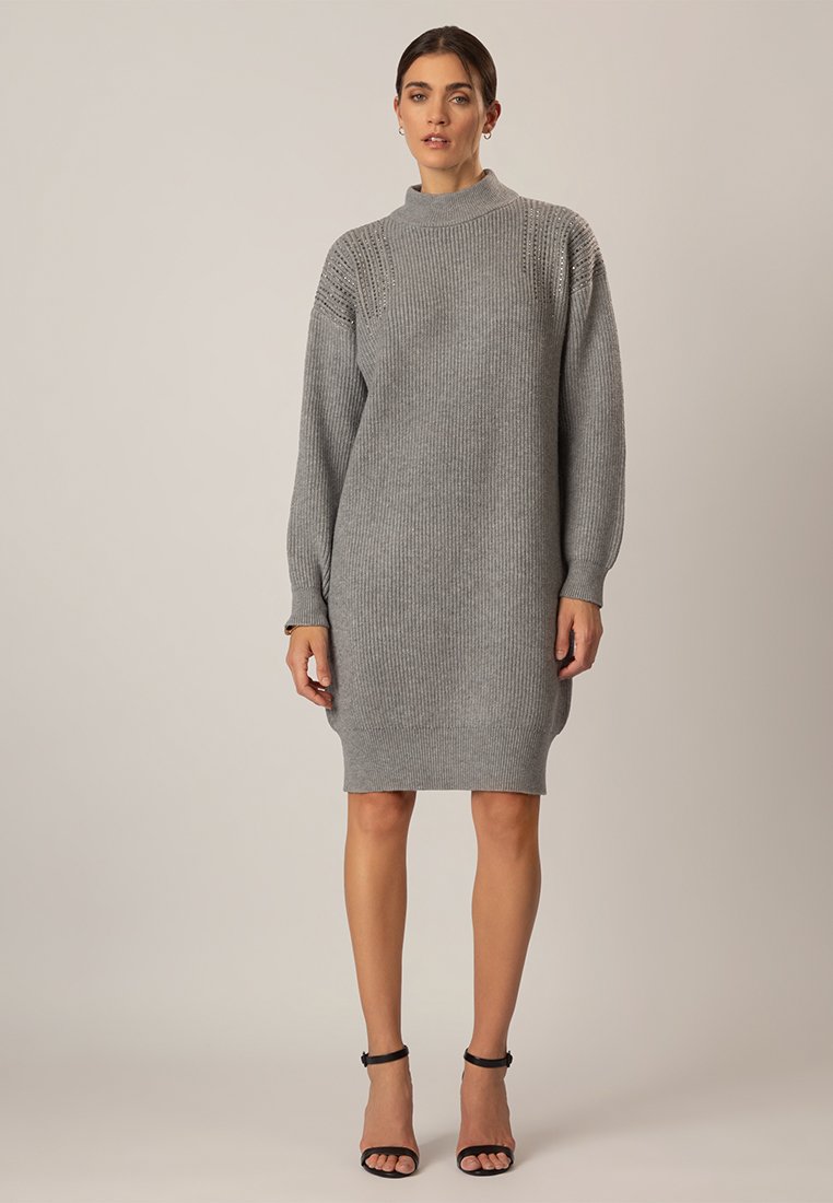 Graues Strickkleid mit hohem Ausschnitt, gerippter Textur, langen Ärmeln und einer figurnahen Silhouette. Glattes Material mit leichtem Stretch.