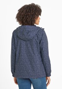 Navy blue patterned jacket with a hood, featuring a floral design, elastic cuffs, and a relaxed fit, made from lightweight fabric.