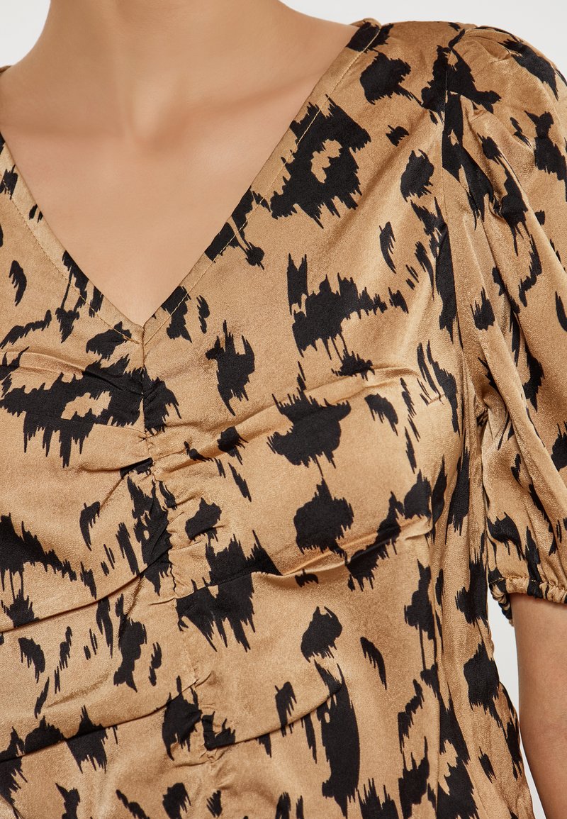 Brun satin top med v-udskæring, sort abstrakt print, puffede ærmer og samlet detalje ved busten og skuldrene.