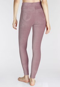 Leggings à taille haute et côtelés dans un mauve doux. Dotés de deux poches arrière et d'une texture lisse, conçus pour un ajustement près du corps.