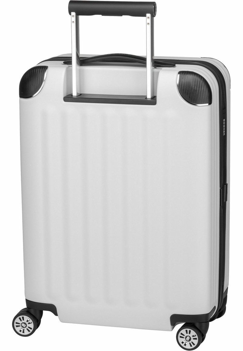 Biała twarda walizka z pionowymi żłobieniami, czarnymi akcentami, wysuwaną rączką i czterema kółkami. Trwała konstrukcja do podróży.
