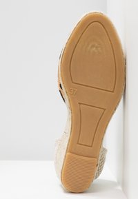 Semelle d'une chaussure compensée fermée taille 37 avec fond en caoutchouc texturé et inscription "Made in Spain".