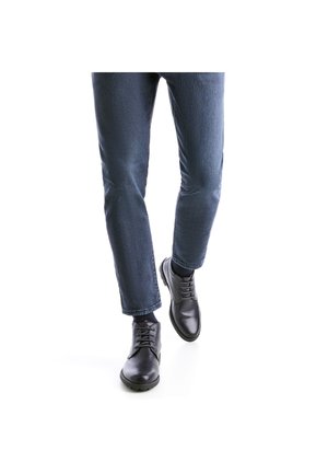 Schwarze Leder Schuhe mit Schnürsenkeln, runder Spitze, flacher Sohle, kombiniert mit blauen Jeans. Die Schuhe haben eine glatte Oberfläche und minimalistische Details.