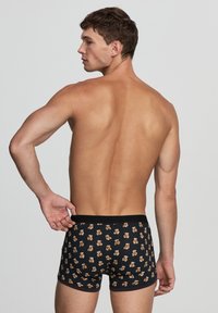 Boxer neri con un motivo di orsetti giocosi, realizzati in tessuto morbido, con un design aderente e vita elasticizzata.