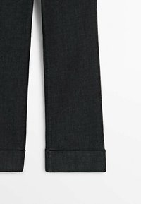 Pantalon en denim noir avec une coupe droite, doté d'une texture subtile et d'un ourlet fini proprement. Sans ornements ni accessoires visibles.