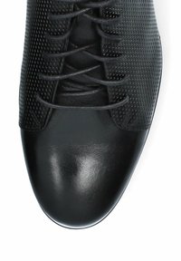 Czarne buty wykonane z gładkiej skóry oraz perforowanego materiału syntetycznego. Sznurowany fason z okrągłym noskiem i elegancką sylwetką.