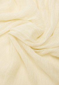 Jasnożółty, półprzezroczysty materiał o miękkiej, teksturowanej powierzchni, z subtelnymi odcieniami i zwiewnym układem.