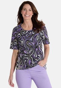 Korte mouwen t-shirt in zwart met ronddraaiende paarse, grijze en witte patronen; zachte stof met een ronde halslijn, gecombineerd met lavendelkleurige broek.