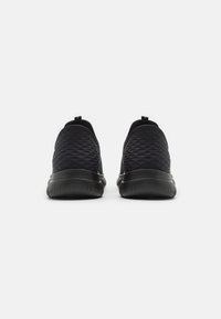 Black slip-on shoes featuring a textured upper with a diamond pattern, padded collar, and a sleek, flexible rubber sole for comfort.