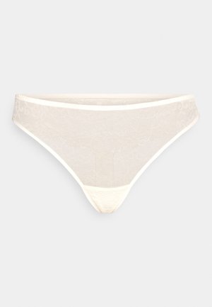 Čipkasti tangice v kremni barvi s cvetličnim vzorcem. Imajo gladek pas in nizko rez, izdelane iz mehkega, elastičnega materiala za udobje.