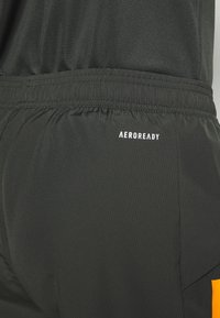 Svarta sportshorts med en texturerad tygkvalitet och ett elastiskt midjeband. Inkluderar en vit "AEROREADY"-logotyp på baksidan.