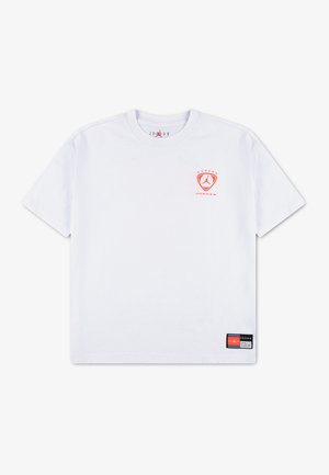 Hvid T-shirt med korte ærmer, lille rødt Jordan-logo på venstre bryst og et sort og rødt mærke nær nederste søm. Ingen synlige personer.