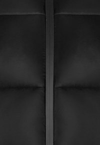 Černá péřová bunda s hladkým, matným povrchem. Obsahuje vertikální zip a výrazné prošívané části.