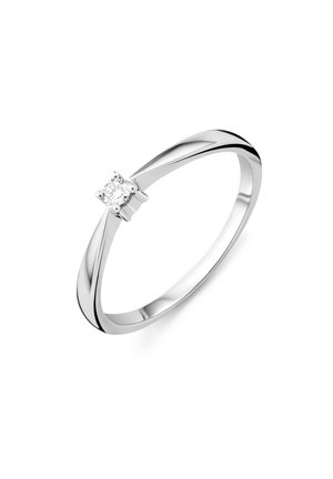 Õhuke hõbedast sõrmus, millel on üks väike ümmargune teemant neljakandilise naelaga valgel taustal.