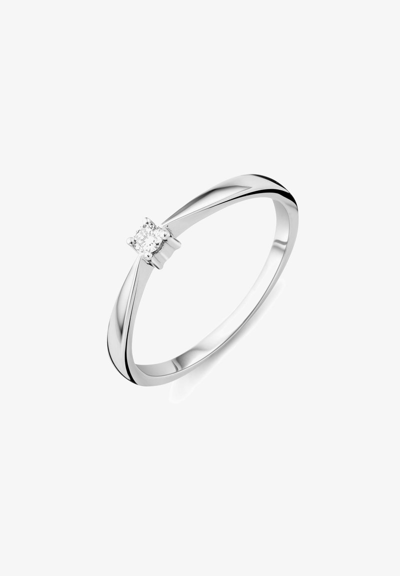 Schmaler silberner Ring mit einem kleinen runden Diamanten, der in einer vier Krappen Fassung gegen einen weißen Hintergrund gesetzt ist.