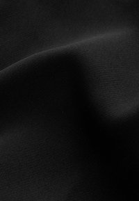 Tissu noir avec une texture lisse, présentant des motifs de tissage subtils et de légers plis, créant une apparence douce et flexible.