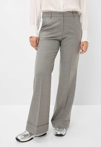 Grijze wijde broek van lichtgewicht stof, met een platte voorkant en knoopsluiting, en een omgeslagen zoom. Gekocht met zilveren sportschoenen.