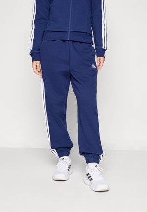 Marine treningsdrakt med hvite sidestrek; jakke med glidelås, smale bukser med ribbede mansjetter, laget av myk, teksturert stoff. Sneakers inkludert.