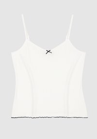 Top blanco de tirantes finos con textura acanalada, acento de lazo negro en el escote y un dobladillo con volantes negros en el borde.