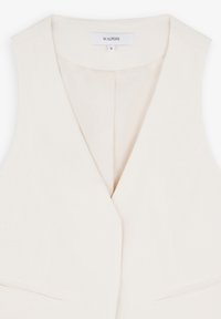 Witte linnen vest met een V-hals, zonder mouwen en zijzakken. Bevat een label met "SCALPERS" en maat "M" op de nek.