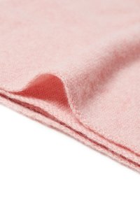 Tessuto di lana rosa chiaro con una superficie texturizzata, caratterizzato da un bordo ripiegato e dettagli fibrosi sottili. Il motivo della trama visibile aumenta la profondità.