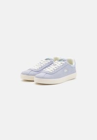 Zapatillas de ante azul claro con cordones blancos y una suela clara. Presentan un pequeño logo bordado en el lateral. Parte superior de textura suave.
