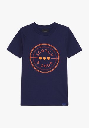 Granatowy t-shirt z krótkim rękawem i okrągłym dekoltem, z pomarańczowym okrągłym logo "Scotch & Soda" umieszczonym na środku przodu.