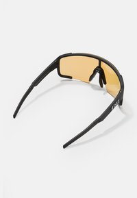 Czarne sportowe okulary przeciwsłoneczne z elegancką prostokątną ramą i żółtymi soczewkami. W zestawie regulowane noski i teksturowane końcówki zauszników.