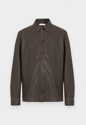 Temno rjava usnjena srajca z dolgimi rokavi, spredaj z gumbi, klasičnim ovratnikom in vidnimi kontrastnimi šivi na šivih in manšetah.