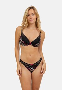 Soutien-gorge en dentelle noire et string assorti affichant une broderie florale colorée, des bords festonnés et des accents de nœuds roses. Texture lisse avec des motifs éclatants.
