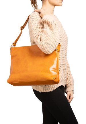 Borsa tote in pelle color tan con finitura lucida, dotata di una lunga tracolla regolabile e forma rettangolare. Maglione lavorato a maglia testurizzato sullo sfondo.