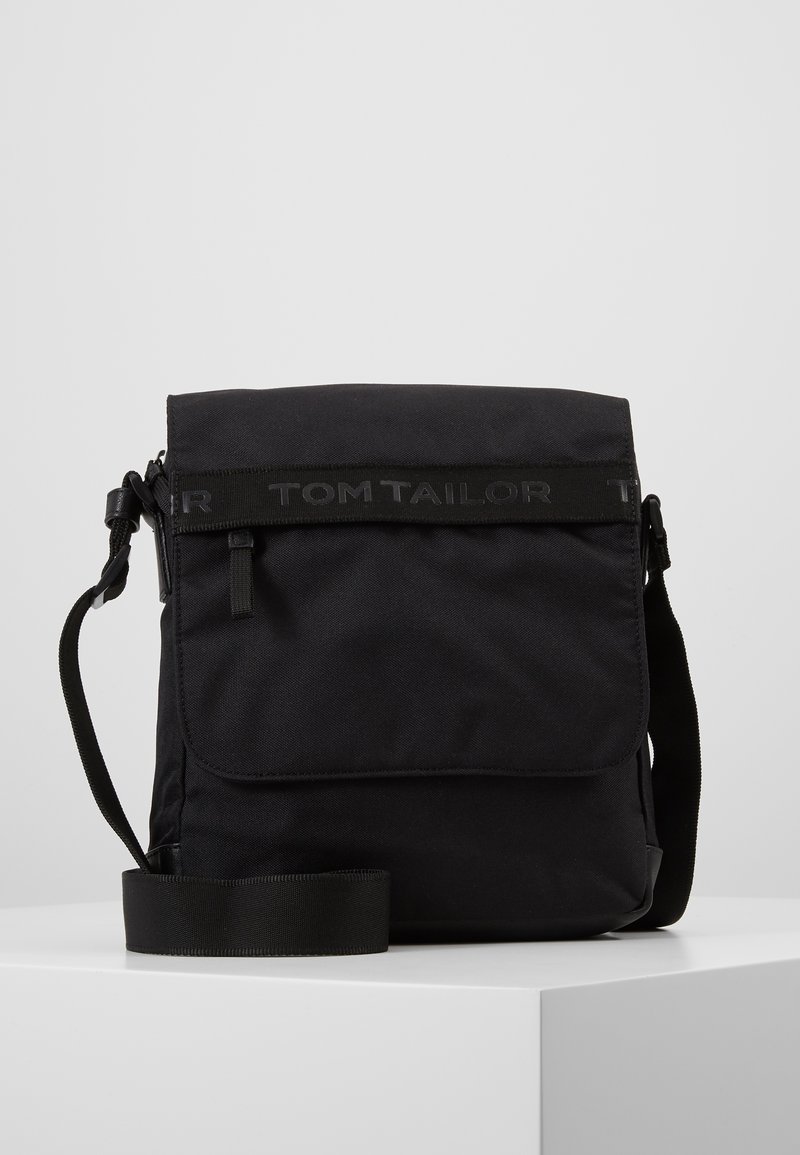 Borsa a tracolla nera realizzata in tessuto resistente, con chiusura a patta, tracolla regolabile e logo impresso sul davanti. Texture liscia.