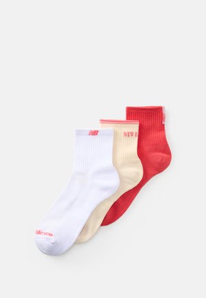 Drei Paar Knöchelsocken: weiß mit pinken Details, beige mit roten Akzenten und rot mit pinken Highlights. Baumwolle mit gerippter Textur.