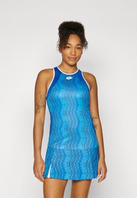 Μπλε αθλητικό φόρεμα χωρίς μανίκια με υφασμάτινο σχέδιο, αντίθετες λευκές λεπτομέρειες και πλαϊνές σχισμές για ελευθερία κινήσεων. Απαλή, ελαφριά υφή.