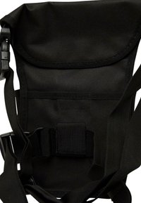 Črna tkaninska torba za ramo z nastavljivimi trakovi, ravnim zapiranjem in zaponkami. Teksturno gradivo, minimalistična zasnova brez vzorcev.