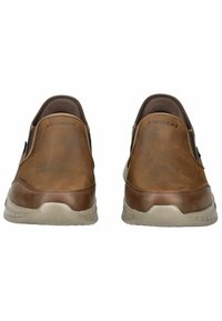 Braune Leder-Schlupfschuhe mit elastischen seitlichen Akzenten, gepolstertem Kragen und einer hellgrauen Gummisohle, die eine strukturierte Oberfläche aufweist.