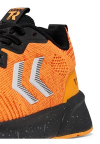 Oranje atletische schoen met een gestructureerde gebreide bovenkant, zwarte accenten, reflecterende strepen en een gemarmerde zwarte zool.